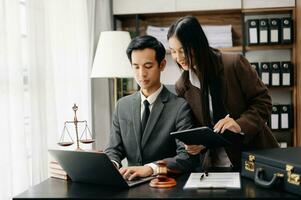 asiático negocio equipo y abogados que se discute contrato documentos sentado a el mesa. conceptos de ley, consejo, legal servicios. a moderno oficina foto