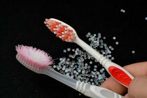 Compare new and old toothbrushes. that is still used every day, black background photo