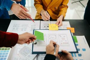 Close up view of UI developer team brainstorming on their project with laptop, smartphone and digital tablet. Creative digital development agency. photo