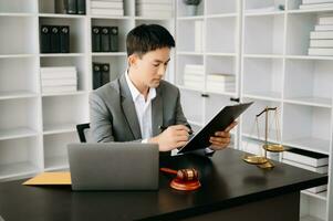 justice and law concept .Asian Male judge in a courtroom on table and Counselor working in office. photo