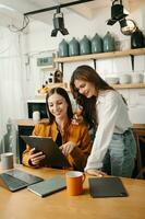 Two business workers talking on the smartphone and using laptop at the office. photo