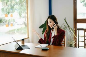 Beautiful Asian business woman typing laptop and tablet Placed at the table at the office photo