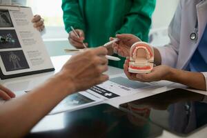 team of dentists is diagnosing inside conference room treating patient toothache. team of doctors and dentists are meeting to find a way to treat root canals that cause pain due to inflammation. photo