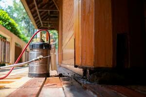 man chose to use exterminate chemicals Termites that are not toxic to humans are mixed with water in a tank for spraying Exterminate termites allow young men to spray termites themselves by himself photo