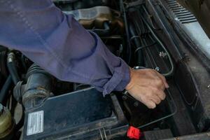 car mechanic is checking condition of engine to make it ready for use and mechanic is still maintaining worn out equipment to return to normal operation. checking engine conditions before traveling photo