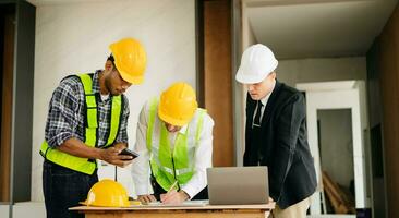Architect caucasian man working with colleagues mixed race in the construction site. Architecture engineering on big project. Building in construction process photo