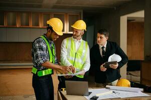 Engineers are discussing data working and laptop or tablet with architectural project at new construction site on big project. interior photo