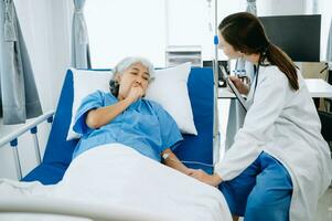 caucásico médico sonriente tomar cuidado de un mayor paciente en hospital. simpático enfermero o terapéutico tratar cliente profesional médico Servicio concepto. foto