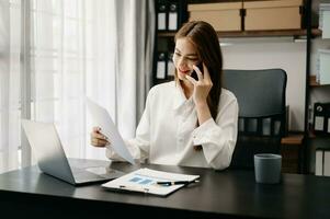 Confident business expert attractive smiling young woman holding digital tablet  on desk in creative office. photo