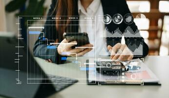 Businessman hand Project manager working and update tasks and Gantt chart scheduling virtual diagram.with smart phone, tablet and laptop in office. photo