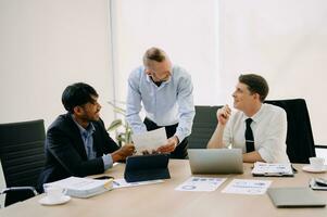 Office colleagues have a casual discussion. During a meeting in conference room, a group of business teem sit in the conference room new startup project photo