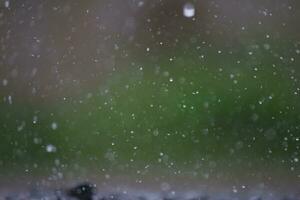 Background of many rain drops falling on the ground due to heavy rain during the rain season causing water splashing from a large number of plots on a blurred background of dark spray. photo