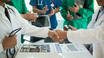 el médico equipo Uniones manos después el reunión y discute el tratamiento de severamente enfermo pacientes y lata ven a un conclusión en el quirúrgico tratamiento de el paciente. médico equipo reunión concepto foto