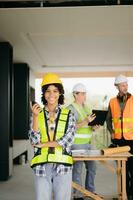 Contractor and architect looking at plan, tablet, laptop and talking about working on big project. Building in construction process interior. team work photo