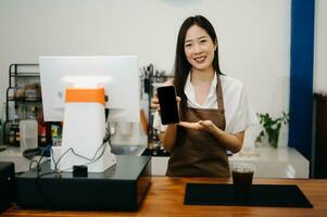 Asian female coffee shop owner in a coffee shop photo