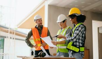 Contractor and architect looking at plan, tablet, laptop and talking about working on big project. Building in construction process interior. team work photo
