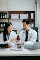 Medical technology network team meeting concept. Asian Doctor hand working with smart phone modern digital tablet and laptop computer with graphics chart interface, photo