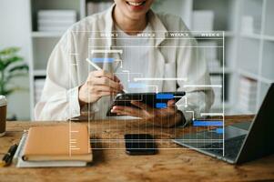 Project manager working and update tasks with milestones progress planning and Gantt chart scheduling diagram. business working with smart phone, tablet and laptop in office. photo