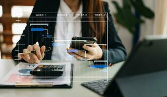 Project manager working and update tasks with milestones progress planning and Gantt chart scheduling diagram. business working with smart phone, tablet and laptop in office. photo