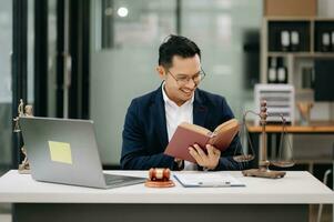 Man lawyer reading legal book with gavel on table in office. justice and law ,attorney concept. photo