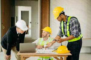 Architect caucasian man working with colleagues mixed race in the construction site. Architecture engineering on big project. Building in construction process photo