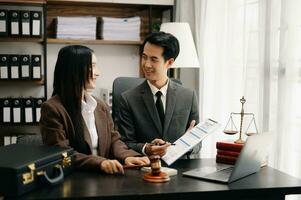 Asian business team and lawyers discussing contract papers sitting at the table. Concepts of law, advice, legal services. at modern office photo