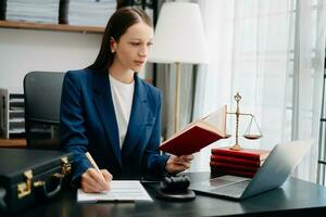 Caucasian Woman lawyer reading legal book with gavel on table in office. justice and law ,attorney concept. photo