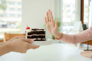 slim female body confuse chocolate cake. Woman in restaurant achieves weight loss goal for healthy life, crazy about thinness, thin waist, nutritionist. Diet, body shape. photo