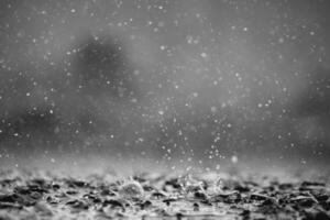 Background of many rain drops falling on the ground due to heavy rain during the rain season causing water splashing from a large number of plots on a blurred background of dark spray. photo