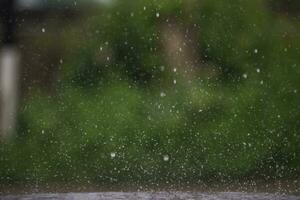 Background of many rain drops falling on the ground due to heavy rain during the rain season causing water splashing from a large number of plots on a blurred background of dark spray. photo