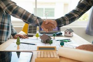 Architects and engineers join hands to congratulate when discussing and successful cooperation in planning construction project. Team of engineers and architects join hands in office after successful photo