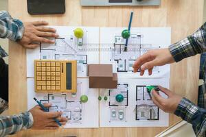 Architects and engineers discuss how to design  housing estate to ensure construction is up to standard and completed on time. team of engineers and architects discuss building design and structure. photo