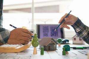 Architects and engineers discuss how to design  housing estate to ensure construction is up to standard and completed on time. team of engineers and architects discuss building design and structure. photo