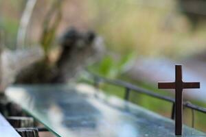 cross representing God in Christianity is placed on mirror and its reflection can be seen on blurred background of nature. cross on background is blurred and there is Copy Space on side for text. photo