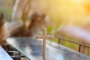 cross representing God in Christianity is placed on mirror and its reflection can be seen on blurred background of nature. cross on background is blurred and there is Copy Space on side for text. photo