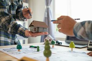 Architects and engineers discuss how to design  housing estate to ensure construction is up to standard and completed on time. team of engineers and architects discuss building design and structure. photo