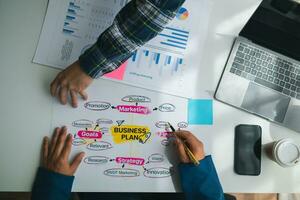 Businessmen and investors form a group of startups and business plans together in a meeting room. A group of startup entrepreneurs are discussing investment plans and profits. photo