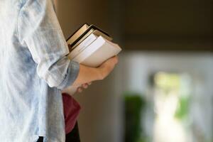 Young woman holding law book in her hand to review and understand law before taking exam to become lawyer. concept of reading books to understand and learn law before taking exam to become lawyer. photo