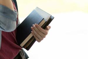 Young woman holding law book in her hand to review and understand law before taking exam to become lawyer. concept of reading books to understand and learn law before taking exam to become lawyer. photo