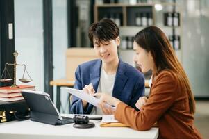 Business people compassionately holding hands and discussing contract papers with laptop and tabletat in office room. photo