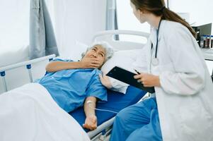 mujer médico y paciente que se discute alguna cosa mientras sentado en examen cama en moderno clínica o hospital . medicina y salud cuidado concepto. foto