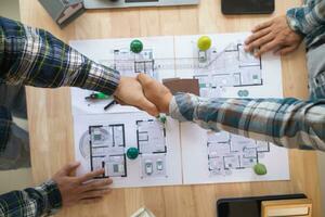 Architects and engineers join hands to congratulate when discussing and successful cooperation in planning construction project. Team of engineers and architects join hands in office after successful photo