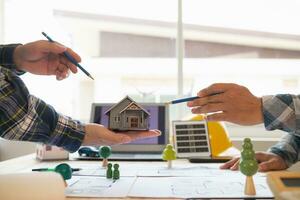 Architects and engineers discuss how to design  housing estate to ensure construction is up to standard and completed on time. team of engineers and architects discuss building design and structure. photo