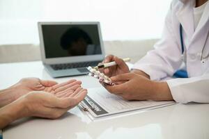 A heart patient visits a doctor for advice on health care and medication to treat heart disease symptoms after the medical team has diagnosed and examined the patient for heart abnormalities. photo