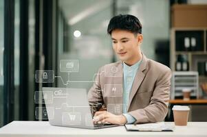 asiático empresario trabajando con ordenador portátil computadora y inteligente teléfono en escritorio en moderno oficina con virtual icono diagrama foto