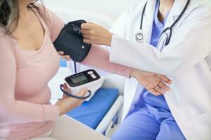 The doctor is using a blood pressure monitor on an elderly patient to check whether the blood pressure is abnormally high or not because hypertension often happens to the elderly and is dangerous. photo