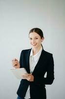 sonriente caucásico joven mujer de negocios banco empleado trabajador gerente jefe CEO mirando a cámara, utilizando tableta, ordenador portátil y bloc en línea aislado en blanco antecedentes foto