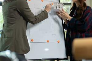Architects and engineers discuss how to design  housing estate to ensure construction is up to standard and completed on time. team of engineers and architects discuss building design and structure. photo