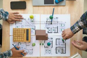 Architects and engineers discuss how to design  housing estate to ensure construction is up to standard and completed on time. team of engineers and architects discuss building design and structure. photo