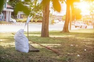 blanco sacos son usado a Contiene muerto hojas ese tener caído según la temporada en primavera como camino a limpiar parque y mezcla hojas a hacer compost. Coco Escoba se sienta siguiente a polvo cucharón y saco para seco hojas. foto